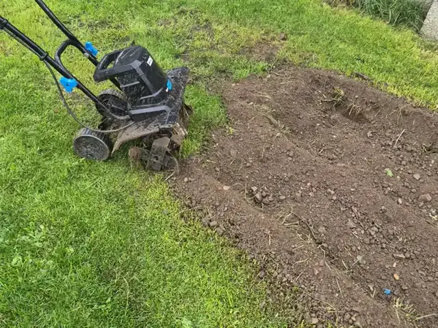 Rotavator turning a patch of lawn into bare soil